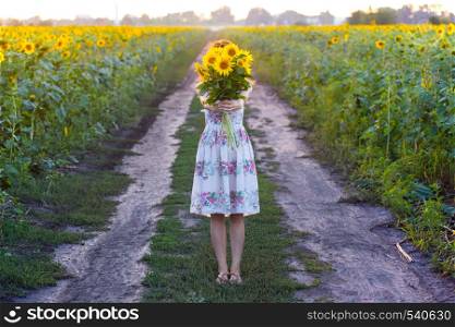 girl holding a huge bouquet of sunflowers in their hands