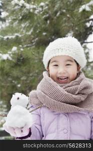 Girl Holding a snowman in a park