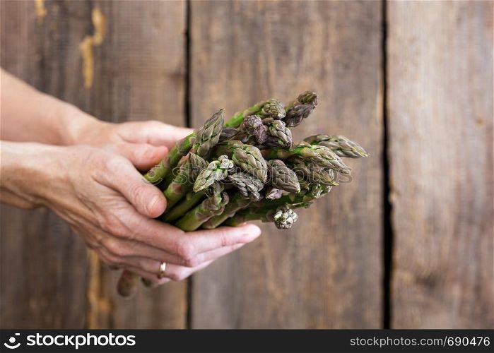 girl holding asparagus in her hands. veganism and raw foods