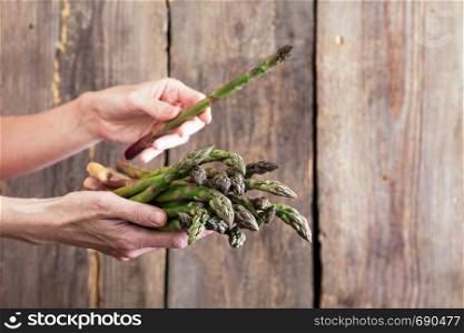 girl holding asparagus in her hands. veganism and raw foods