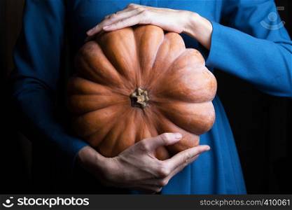 girl holding beautiful aesthetic pumpkin on a black background