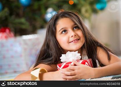 Girl holding Christmas present on floor