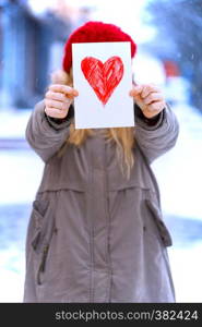 girl holding drawing with a heart on the valentines day