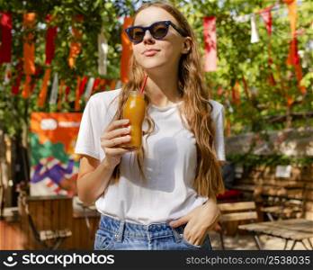 girl holding fresh juice bottle park