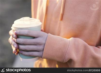 girl holding glasses of coffee in the sunset light 