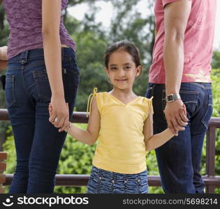 Girl holding her parents hands