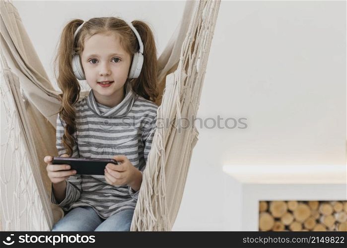 girl holding mobile phone wearing headphones