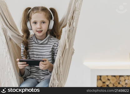 girl holding mobile phone wearing headphones