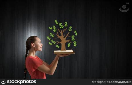 Girl holding opened book. Young woman in red dress with opened book in hand and green tree on pages