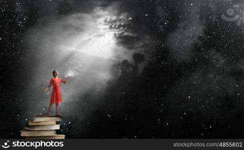 Girl holding opened book. Young woman in red dress with opened book in hand