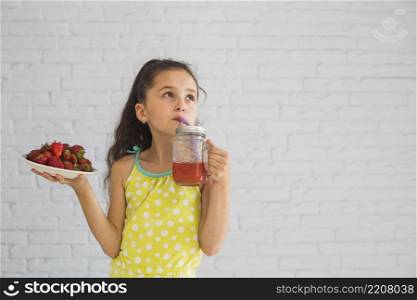 girl holding plate red strawberries drinking strawberry smoothies