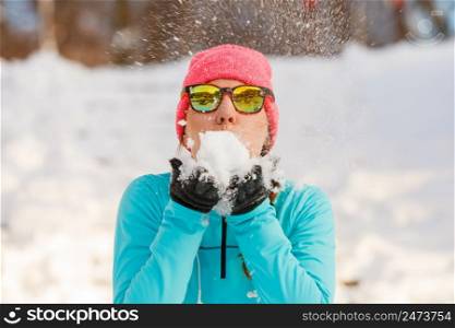Girl holding snow in park. Relax fitness during the winter. Health nature fashion concept. . Girl holding snow in park