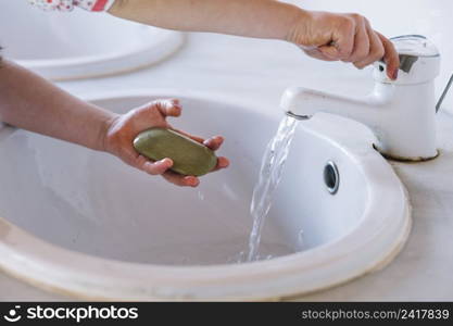 girl holding soap while washing hand washbasin