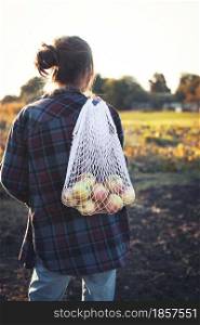 girl holds bag from macrame with juicy apples. aesthetics of rural life