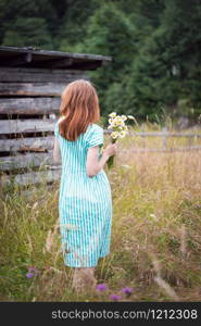 girl holds bouquet of camomile in hands