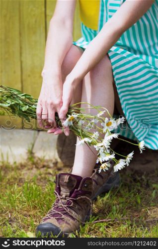 girl holds bouquet of camomile in hands