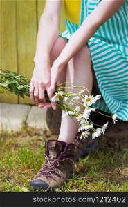 girl holds bouquet of camomile in hands