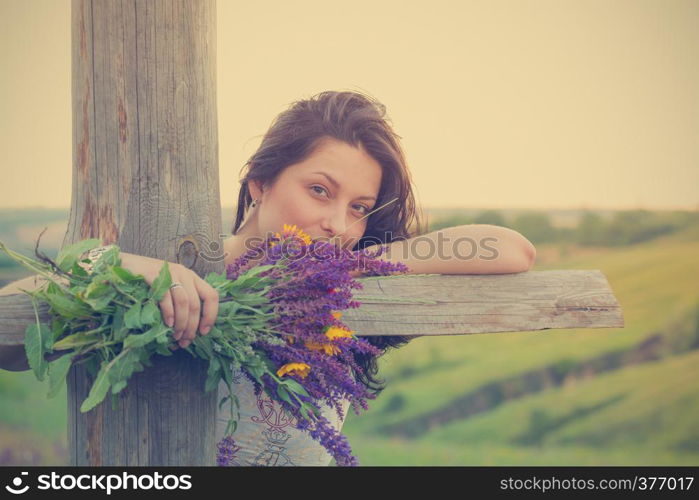 girl holds bouquet of salvia and camomile