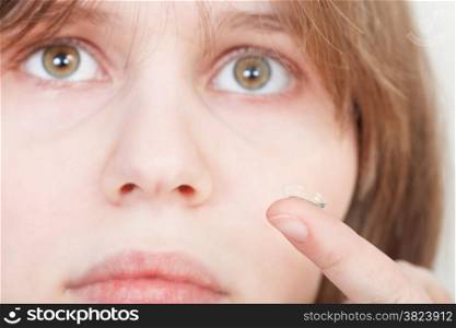 girl holds contact lens on your finger near the eyes