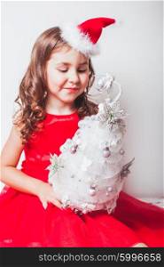 Girl holds in her hands handmade decor - Christmas tree from silver ribbon. Handmade decor - Christmas tree