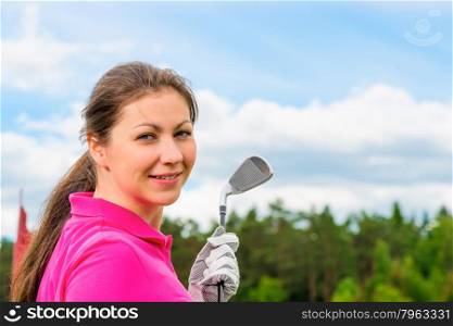 girl in a bright pink T-shirt with a golf club