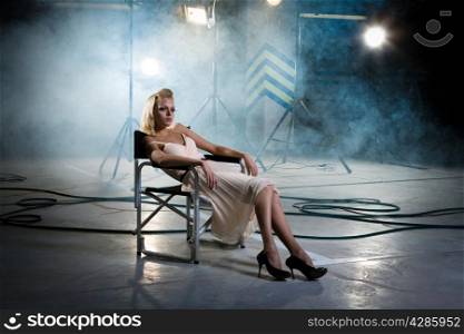 girl in a chair under the rays of searchlights