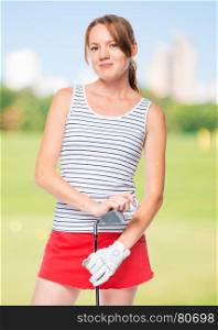 Girl in a striped T-shirt posing with a golf club on a background of golf courses