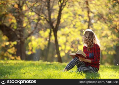girl in a sunny park reading a book