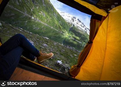 girl in a tent with a beautiful landscape in the background
