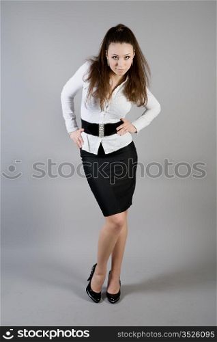 girl in a white blouse and a black skirt on a gray background