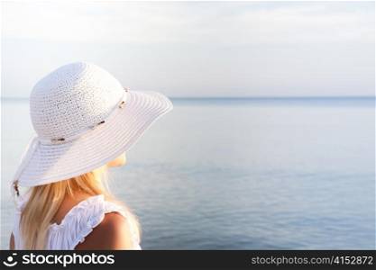 Girl in a white hat on the beach. Travel collection.