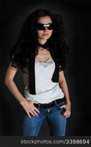 Girl in a white shirt and jeans on a black background