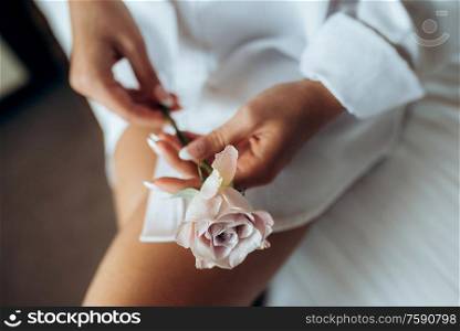 girl in a white shirt holds a rose in her hands