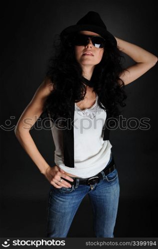 Girl in a white T-shirt, hat and sunglasses on a black background