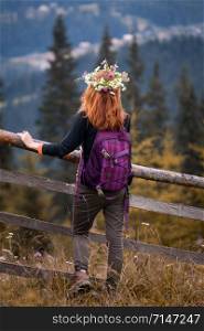 girl in a wreath of wildflowers in the mountains.