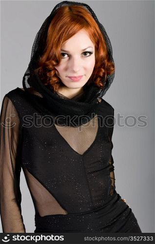 girl in an elegant black dress on a gray background