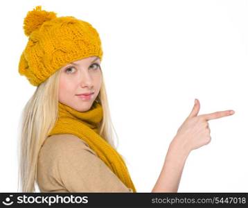 Girl in autumn clothes pointing on copy space