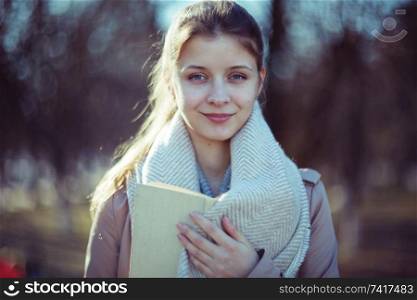 girl in autumn park with a book