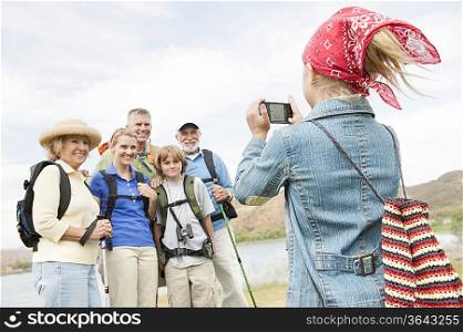 Girl in bandana photographing family on activity holiday