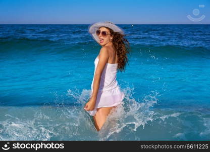 Girl in beach sea shore with waves splash and summer white dress