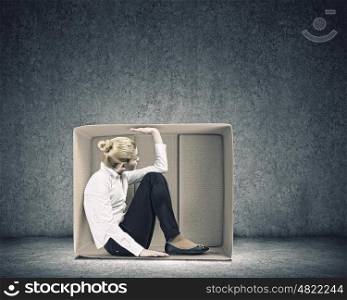 Girl in box. Young businesswoman trapped in carton box