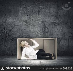 Girl in box. Young emotional woman trapped in carton box