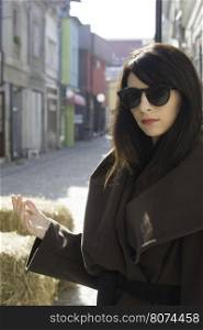 Girl in brown wool jacket on a street.