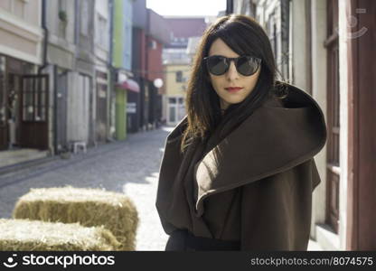 Girl in brown wool jacket on a street.