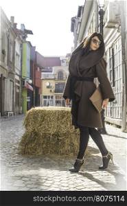 Girl in brown wool jacket on a street.