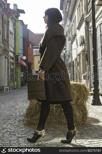 Girl in brown wool jacket on a street.