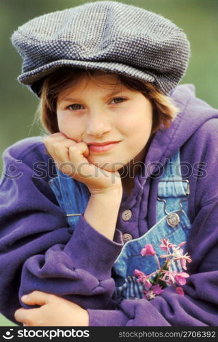 Girl in cap and sweatshirt with head in hands