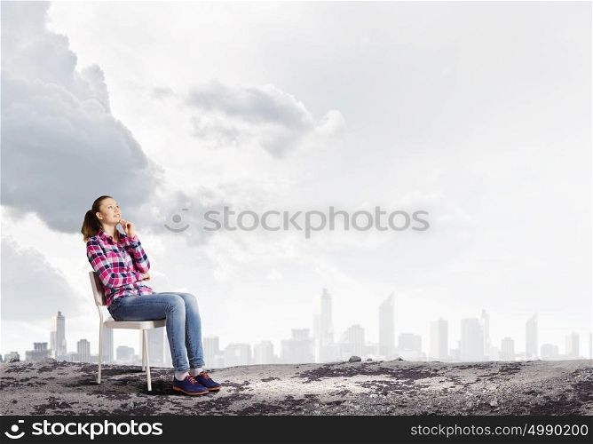 Girl in chair. Young girl sitting in chair against city background