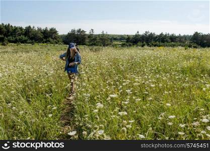 Girl in flowering field at Cavendish Dunelands Trail, Green Gables, Prince Edward Island, Canada