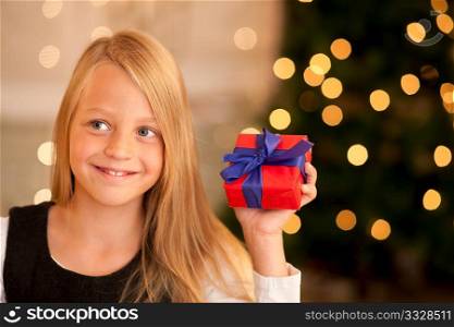 Girl in front of a Christmas tree with presents